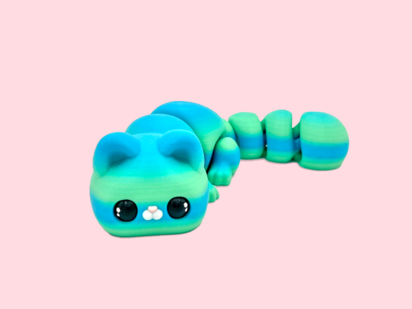 Colorful cat figurine on pink background.