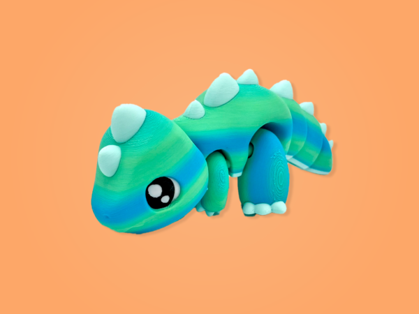 Colorful toy dinosaur with spikes on orange background
