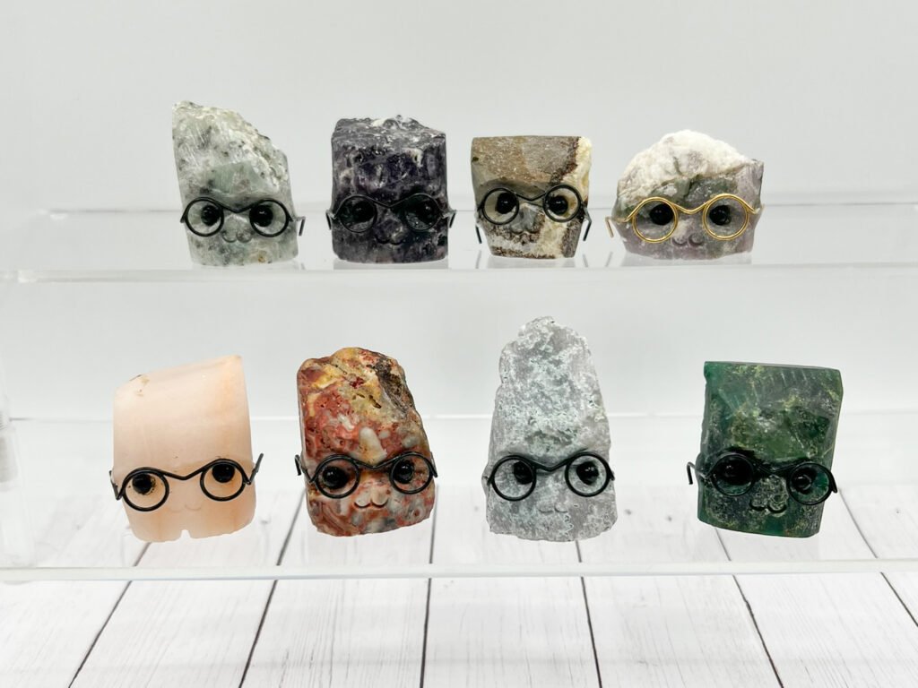 Cute rock characters with glasses on display shelves.