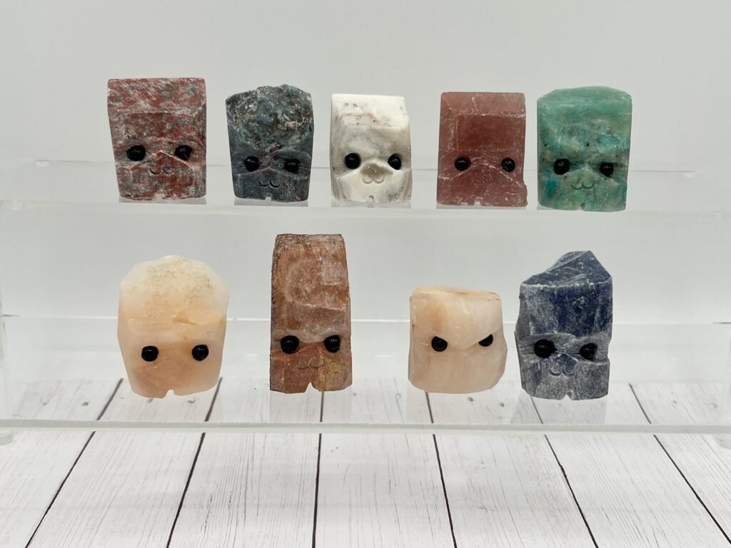 Cute mineral figures with faces on display shelves.