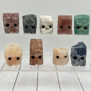 Cute mineral figures with faces on display shelves.