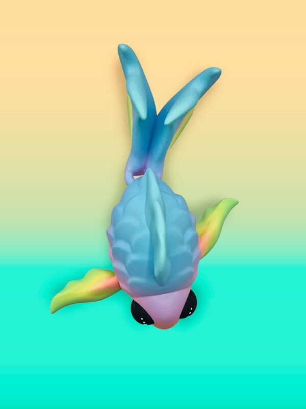 Colorful koi fish toy on bright gradient background.